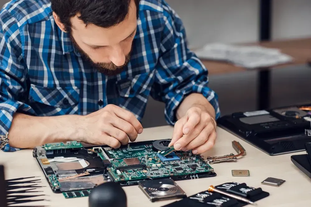 Man in Blue Plaid Shirt Repairs a Circuit Board — Rescuetech Computer And iPhone Repairs in Ballina, NSW