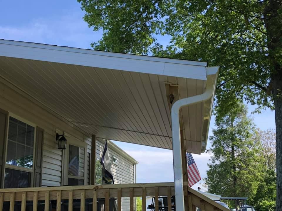 A mobile home with a porch and an american flag on it.