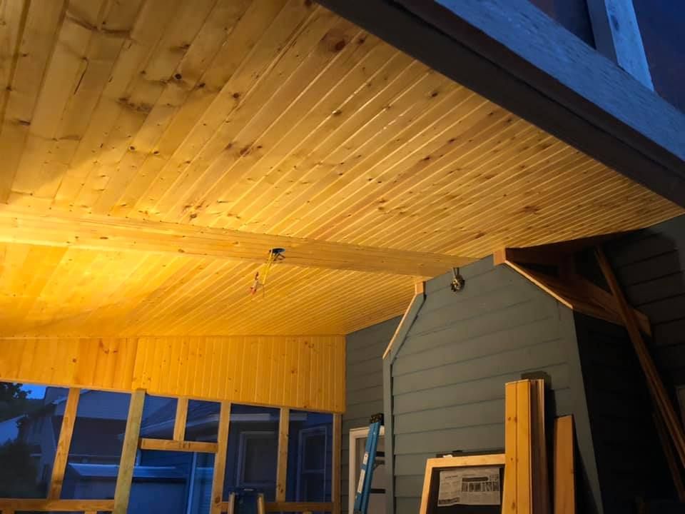 A wooden ceiling with a ladder in the background.