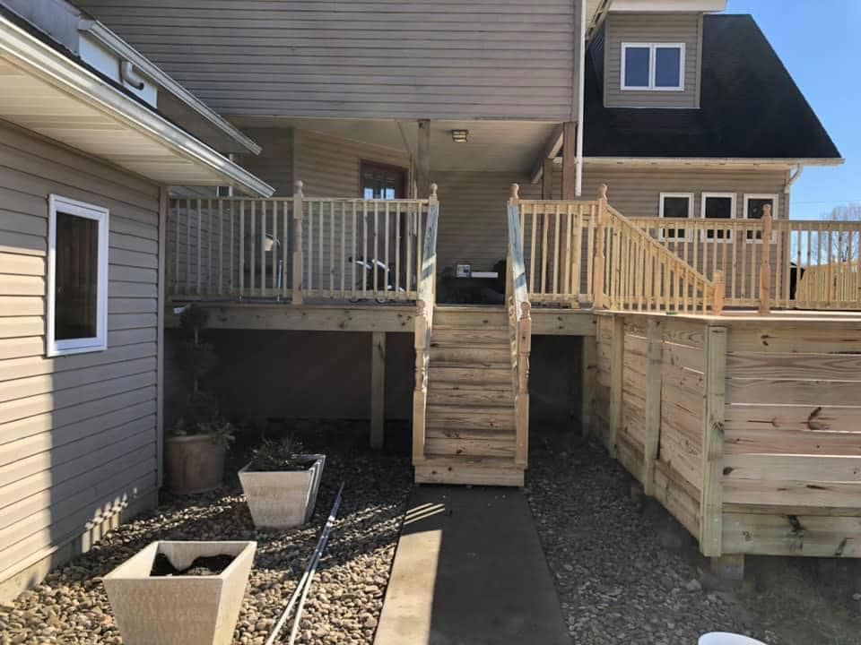 A house with a wooden deck and stairs leading up to it.