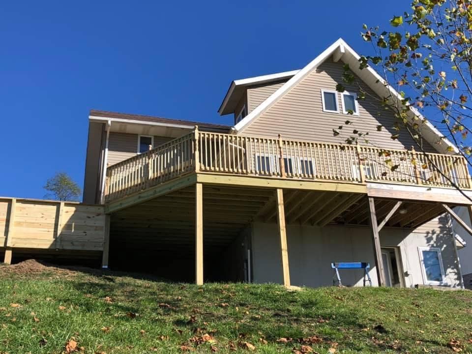 A house with a large wooden deck on the side of it.