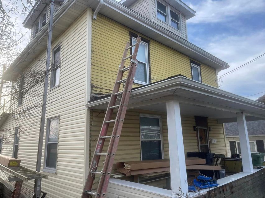 A ladder is sitting on the porch of a house.