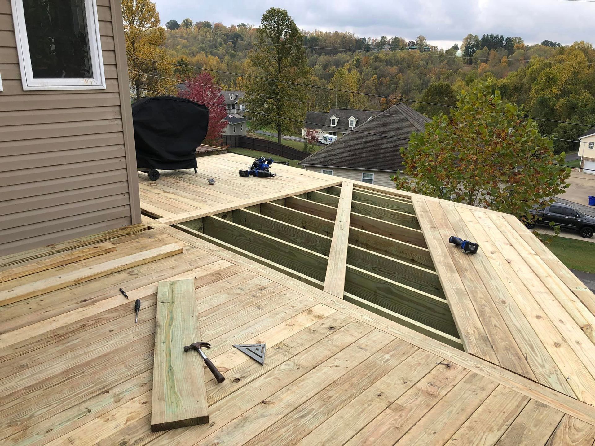 A wooden deck is being built on the roof of a house.