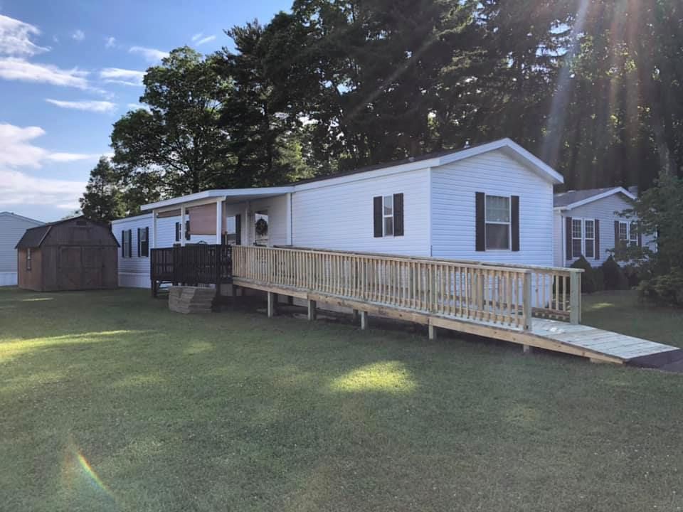 A mobile home with a ramp in front of it.
