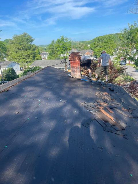 A man is working on the roof of a house.