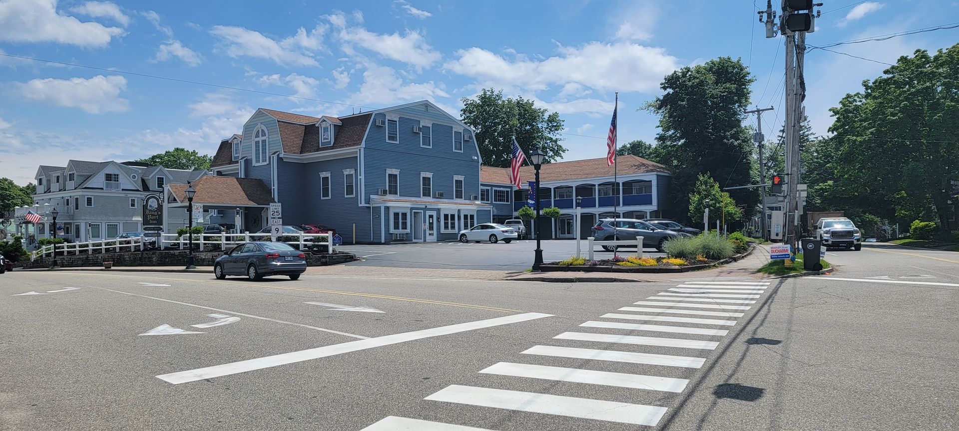 A street corner with a crosswalk and a building in the background.