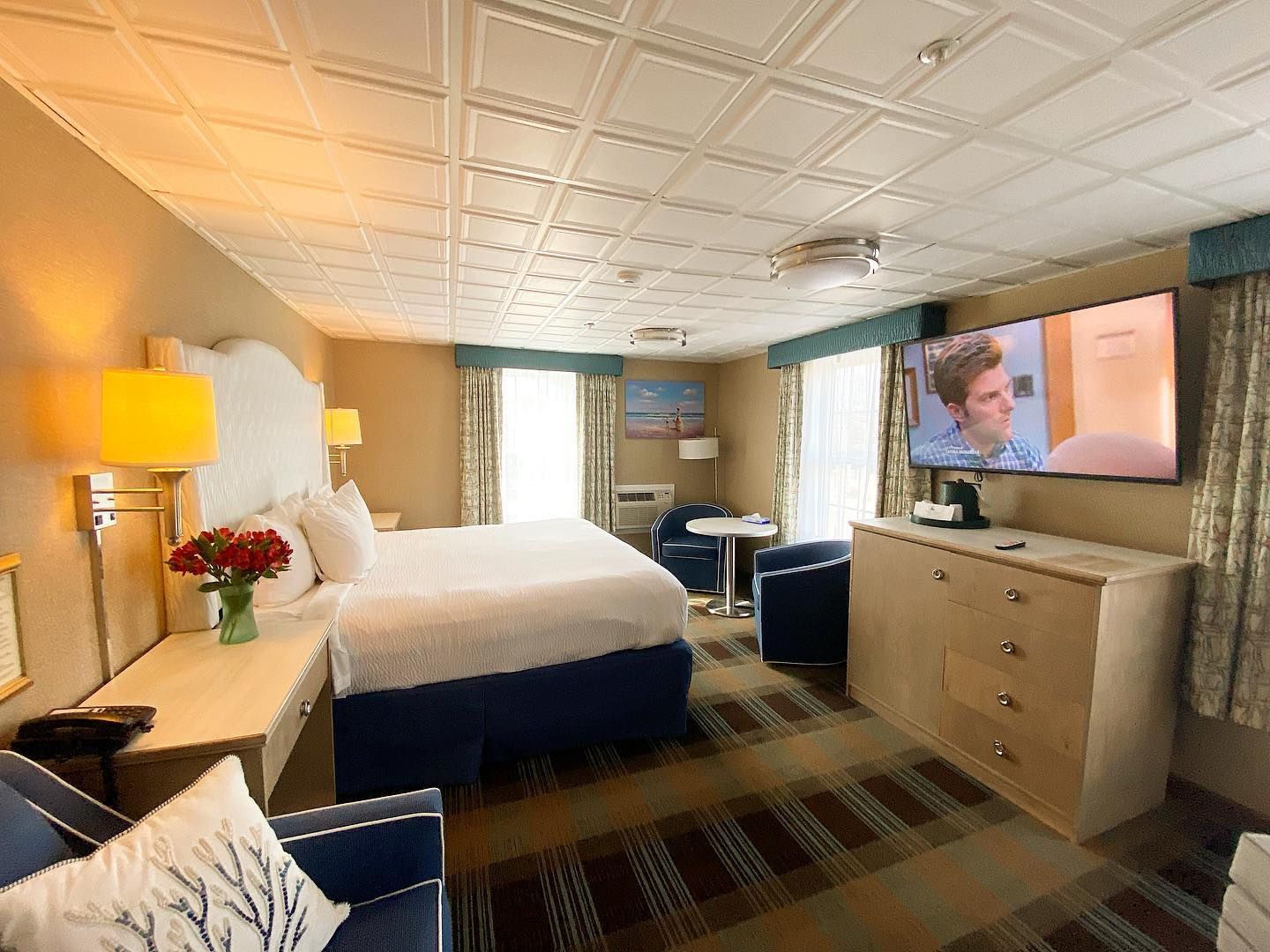 A hotel room with a king size bed and a flat screen tv.