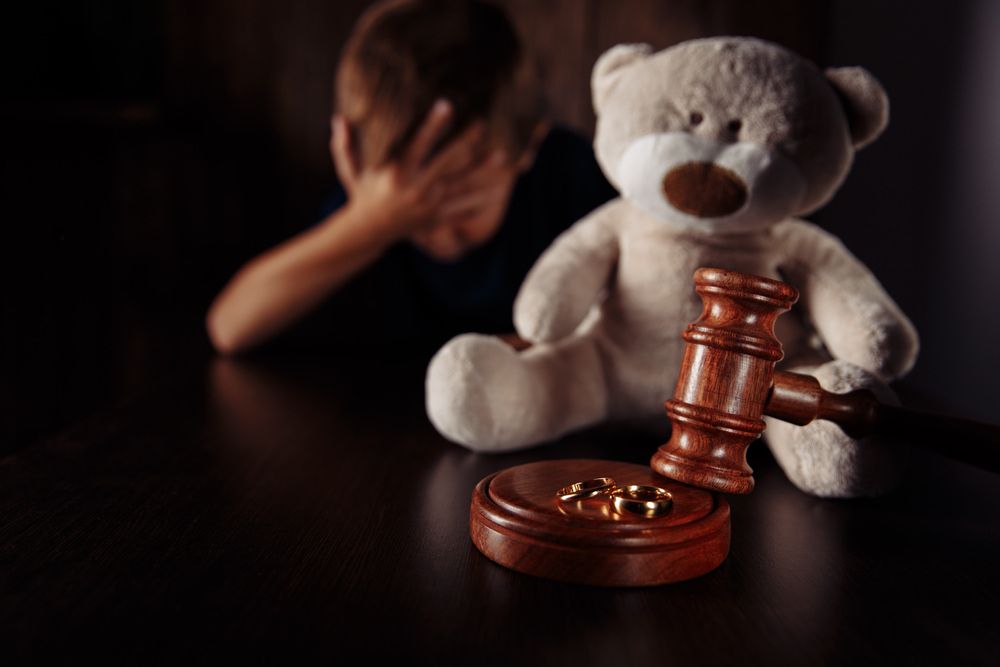 A Teddy Bear Is Sitting On A Table Next To A Wooden Gavel — McNeilly Lawyers In Kempsey, NSW