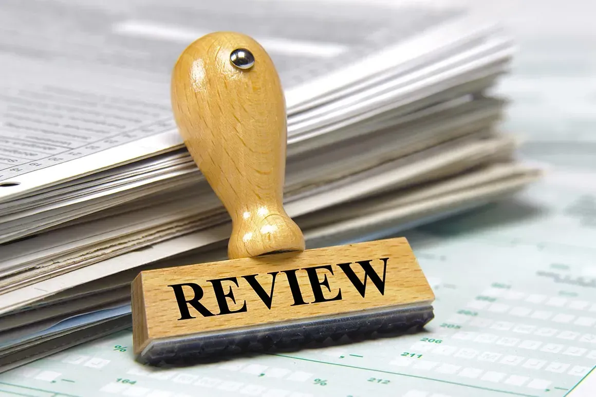 A Wooden Stamp With The Word Review Written On It — McNeilly Lawyers In Kempsey, NSW