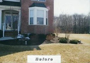 A before picture of a brick house with a large bay window.