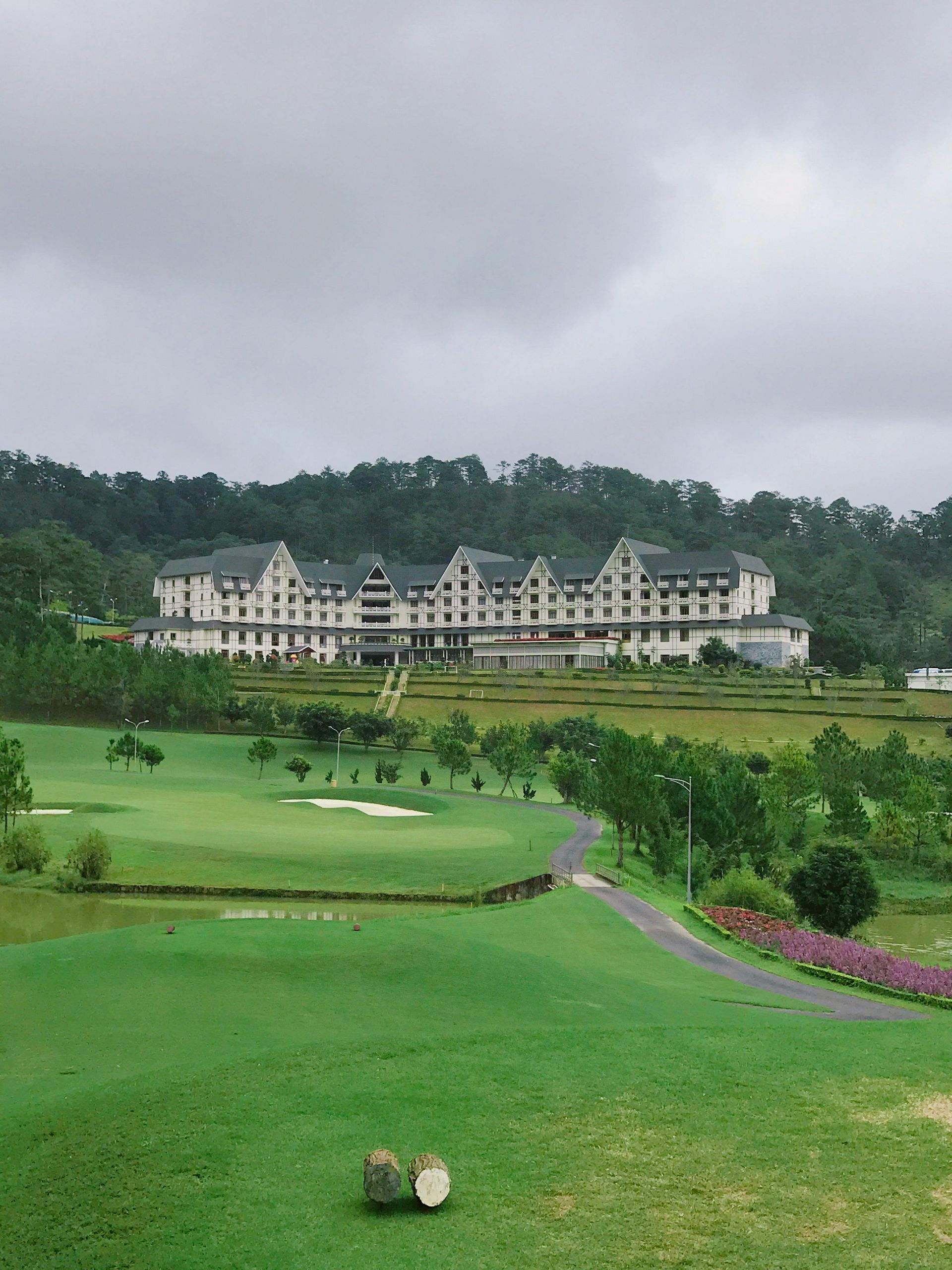 Golf resort with a large building in the background on a cloudy day.