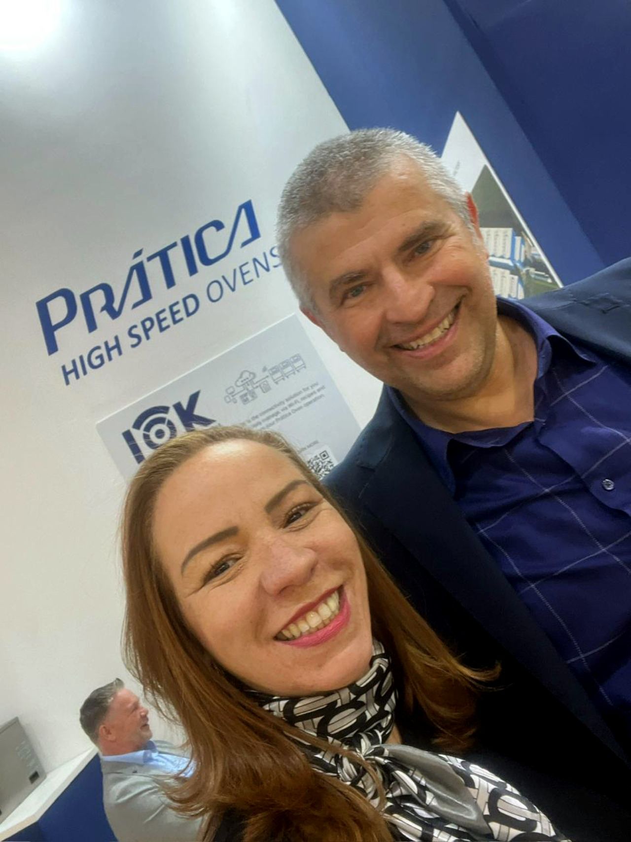 Woman and man smiling, taking a selfie at a 