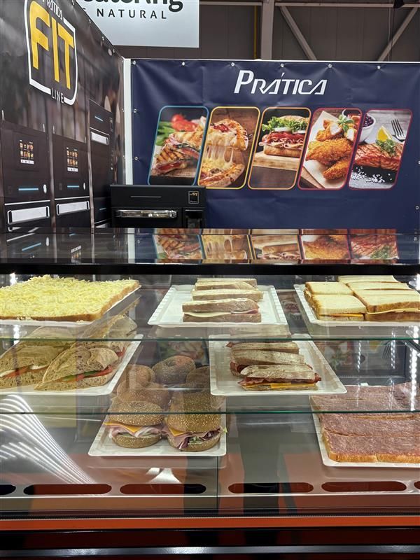 Display case with sandwiches and pastries for sale at a food industry trade show.