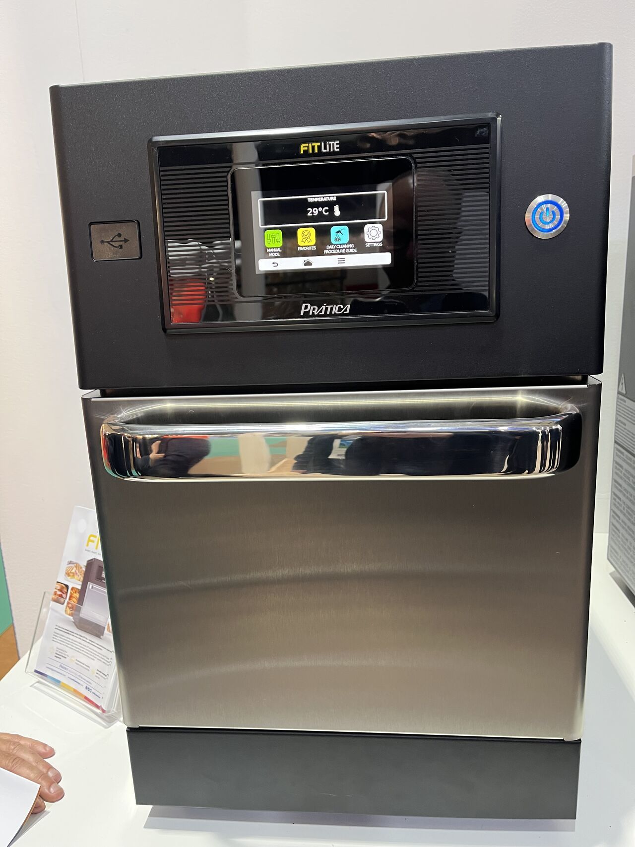 Black and silver industrial oven with touchscreen control panel and handle.