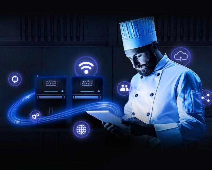 Chef using tablet, connected to digital kitchen equipment, with blue glowing icons.