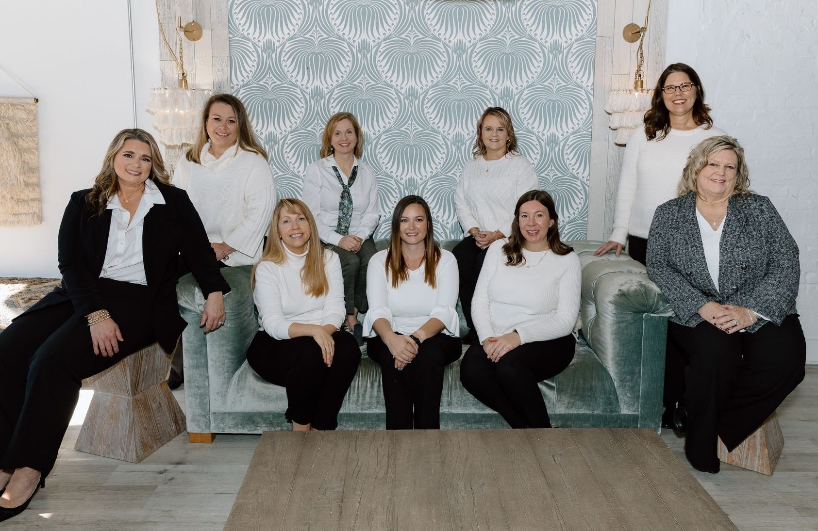 a group of women are posing for a picture while sitting on a couch .