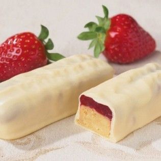 Two white chocolate covered strawberry-filled bars with strawberries.