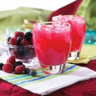 Two glasses of pink berry juice with ice, bowl of berries, and a striped napkin.