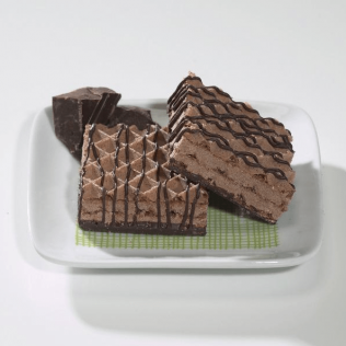 Chocolate wafer ice cream sandwiches on a white plate, drizzled with chocolate.