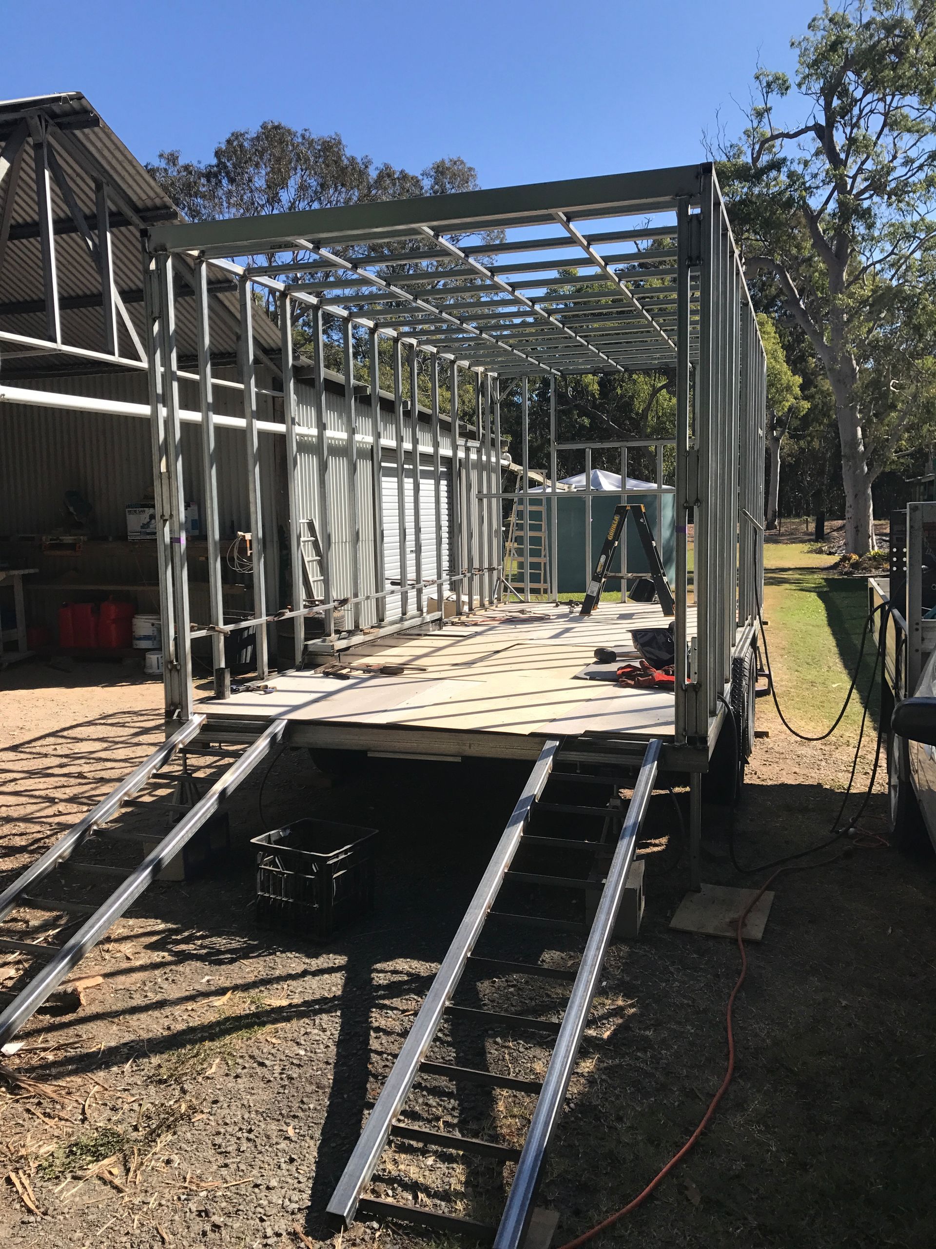 Partially built house frame on a raised platform with metal roof trusses and a ramp leading up.  — Jensen Welding & Fabrication in Chevallum, QLD