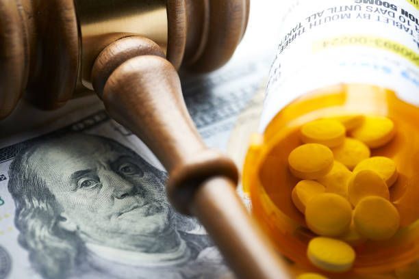 A judge 's gavel is sitting on top of a bottle of pills.