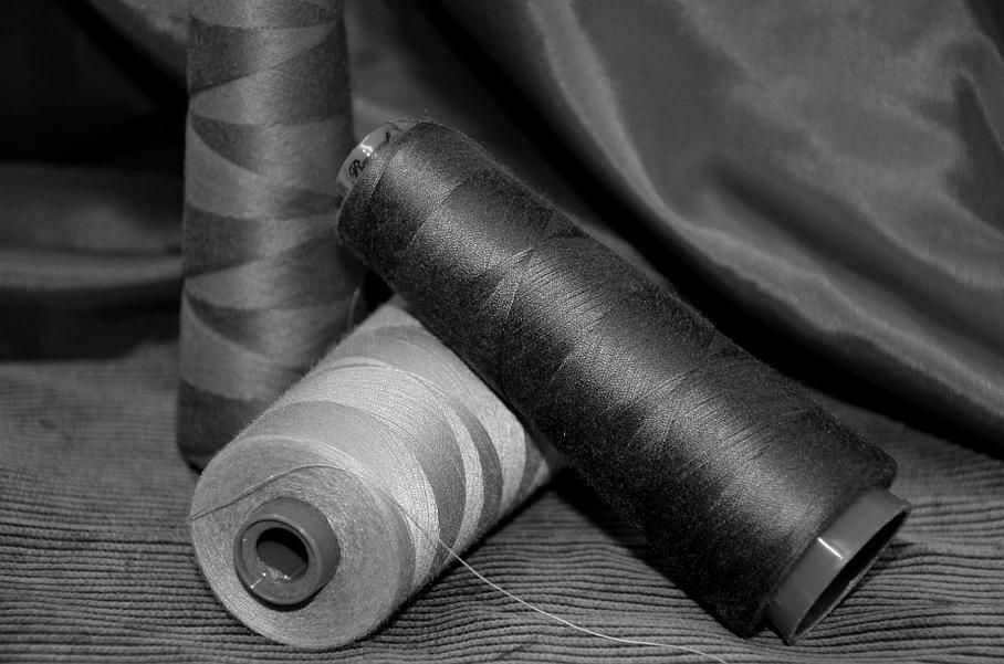 Une photo en noir et blanc de trois bobines de fil