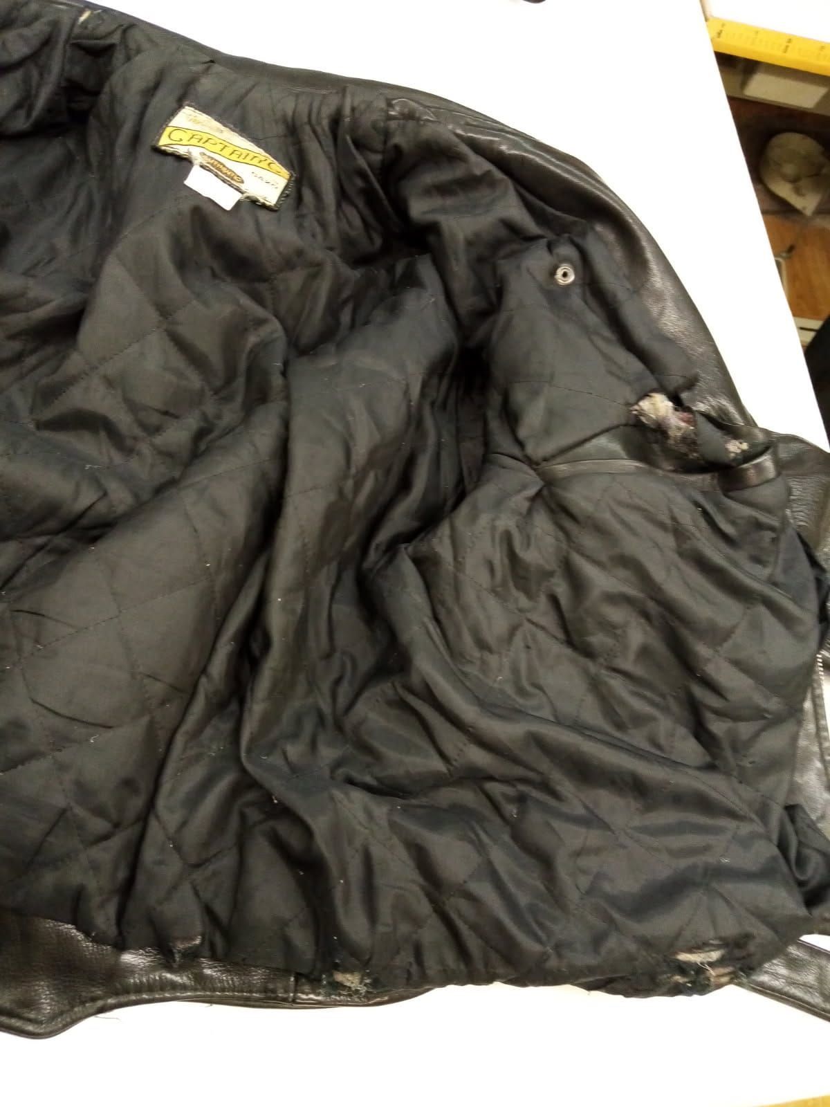 Intérieur d'un blouson en cuir noir avant intervention de la couturière