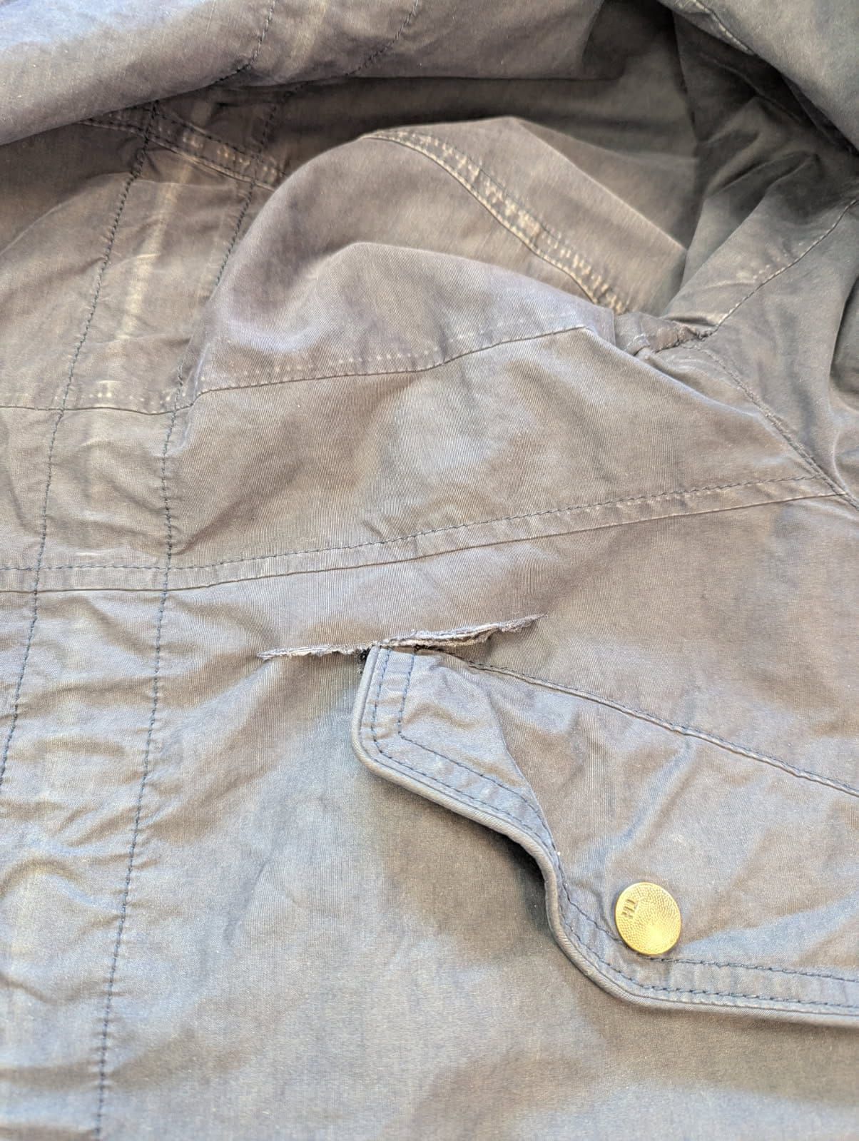 Doublure de veste déchirée avant réparation