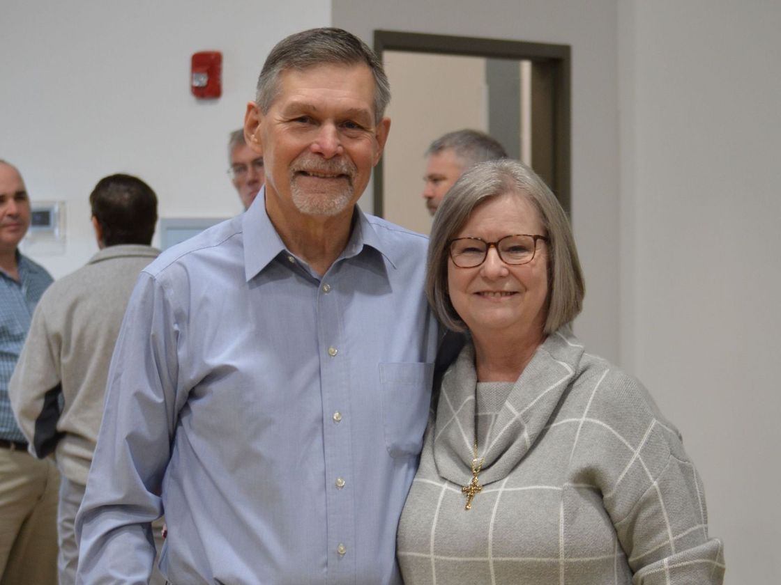 A man and a woman are posing for a picture in a room.
