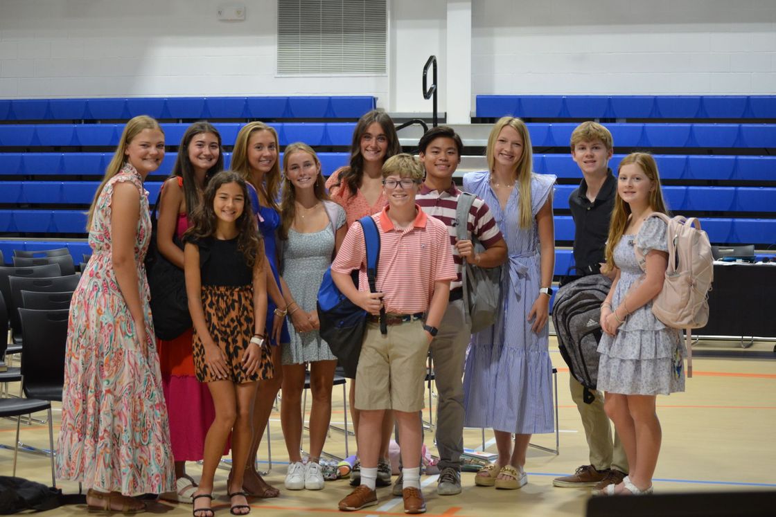 A group of young people are posing for a picture in a gym.