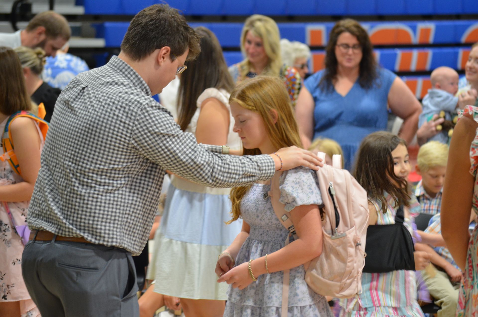 Cody Prewitt, youth pastor, blesses the children during annual Blessing the Backpacks service.