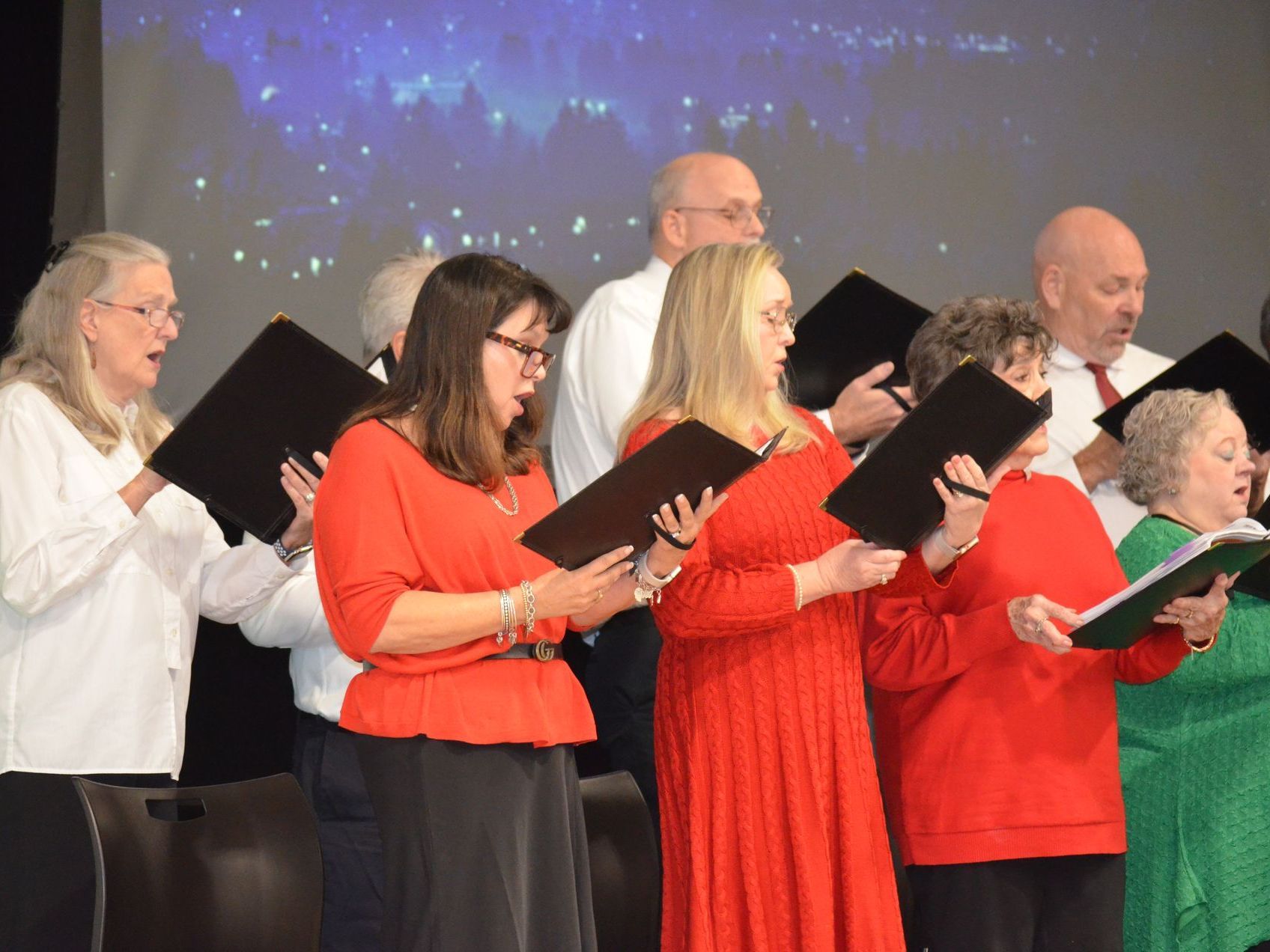 A group of people are singing in a choir.