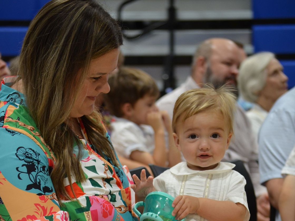 A woman is holding a baby in her arms.