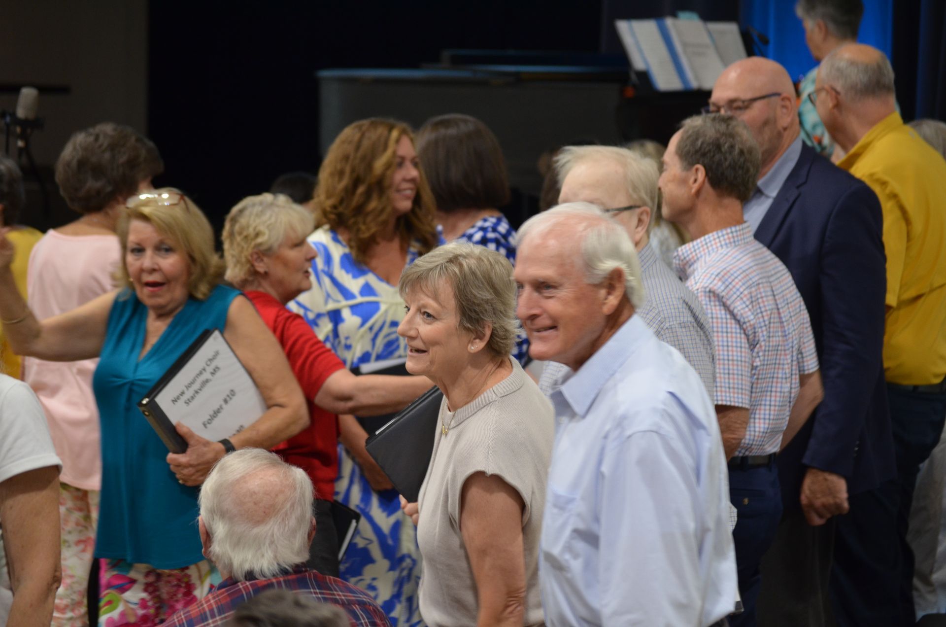 A group of people are standing in a line talking to each other.