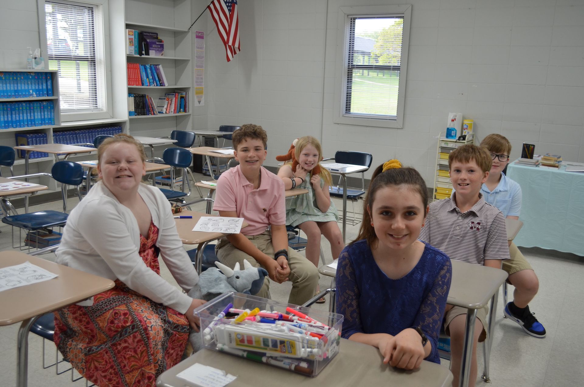 A group of children are sitting at desks in a classroom.