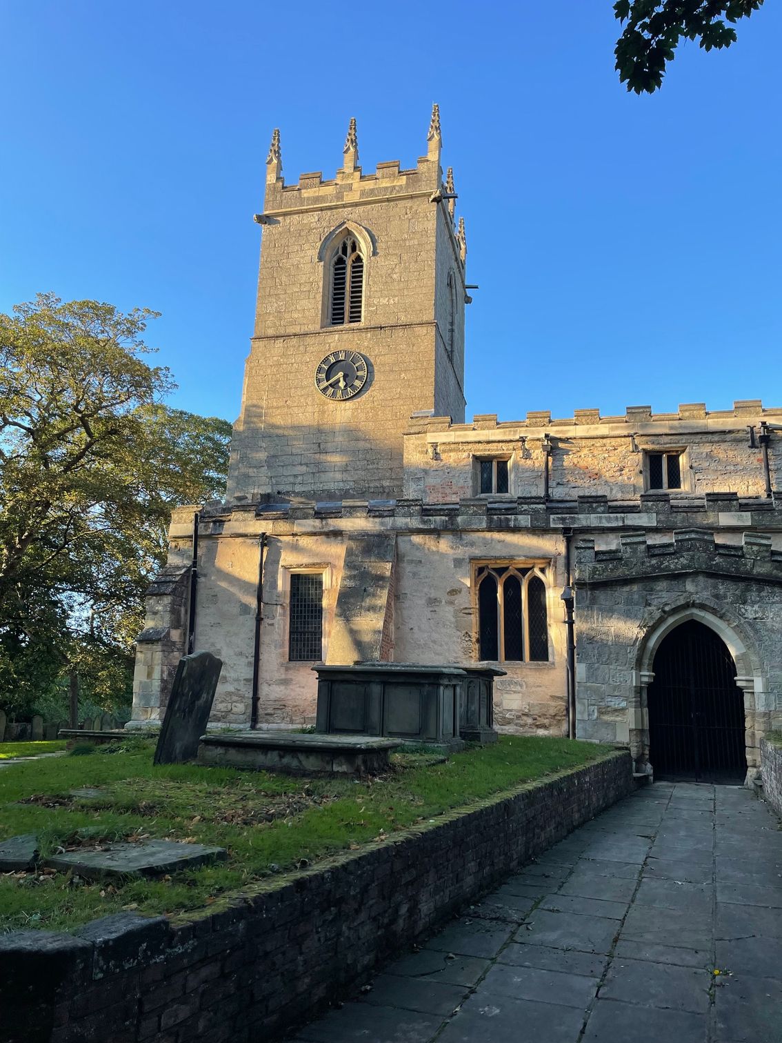 Stone church with a clock tower under a clear blue sky.