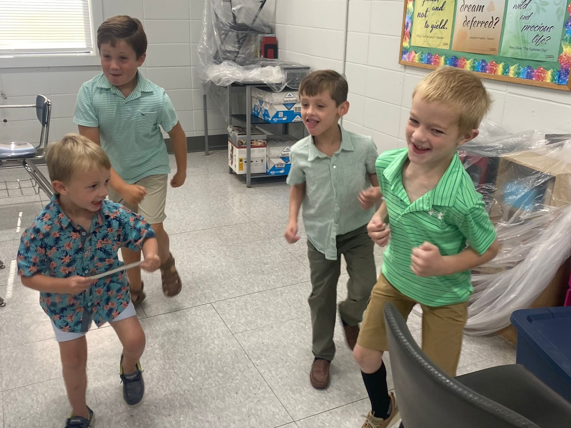 A group of young boys are dancing in a classroom.