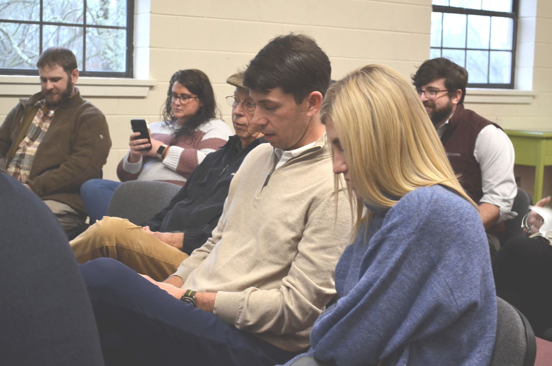 A group of people are sitting in chairs in a room.