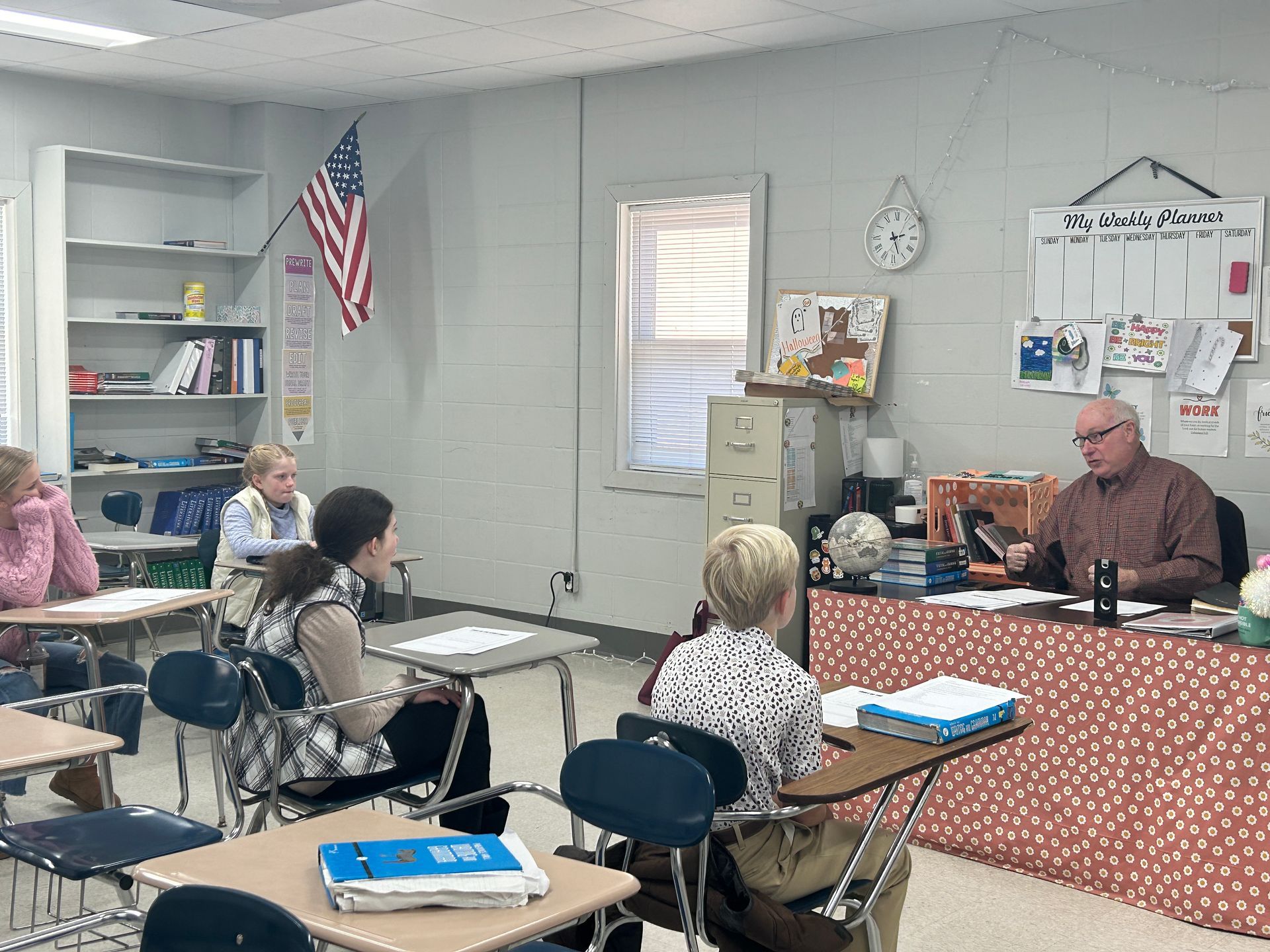A group of people are sitting at desks in a classroom