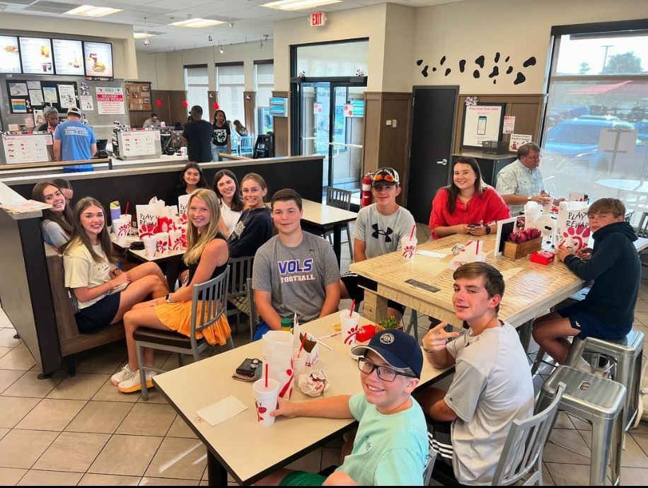 A group of people are sitting at tables in a restaurant.