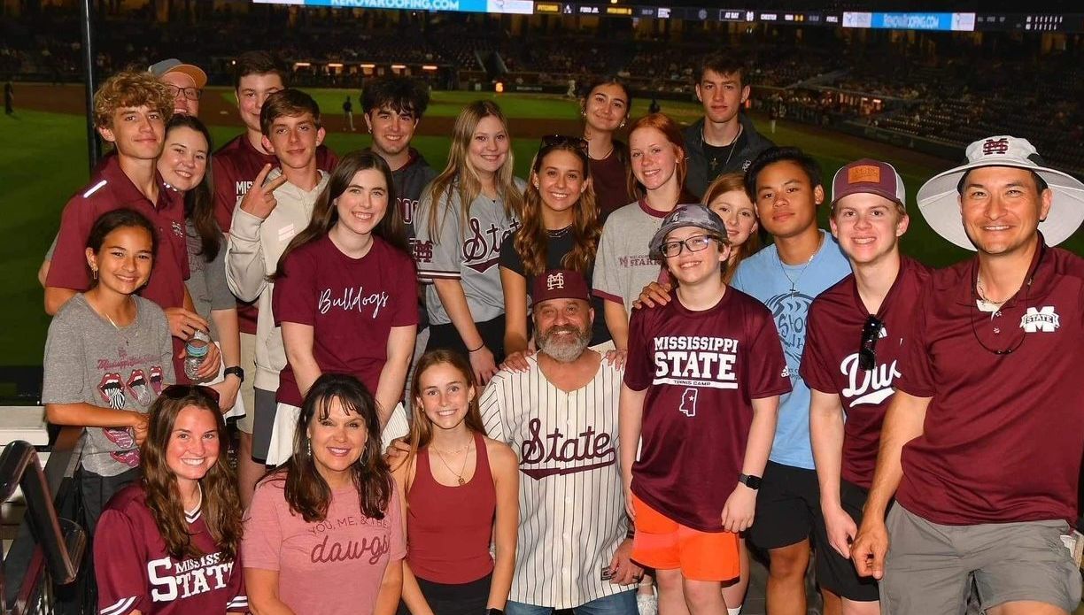 A group of people posing for a picture with one wearing a shirt that says ' smith ' on it