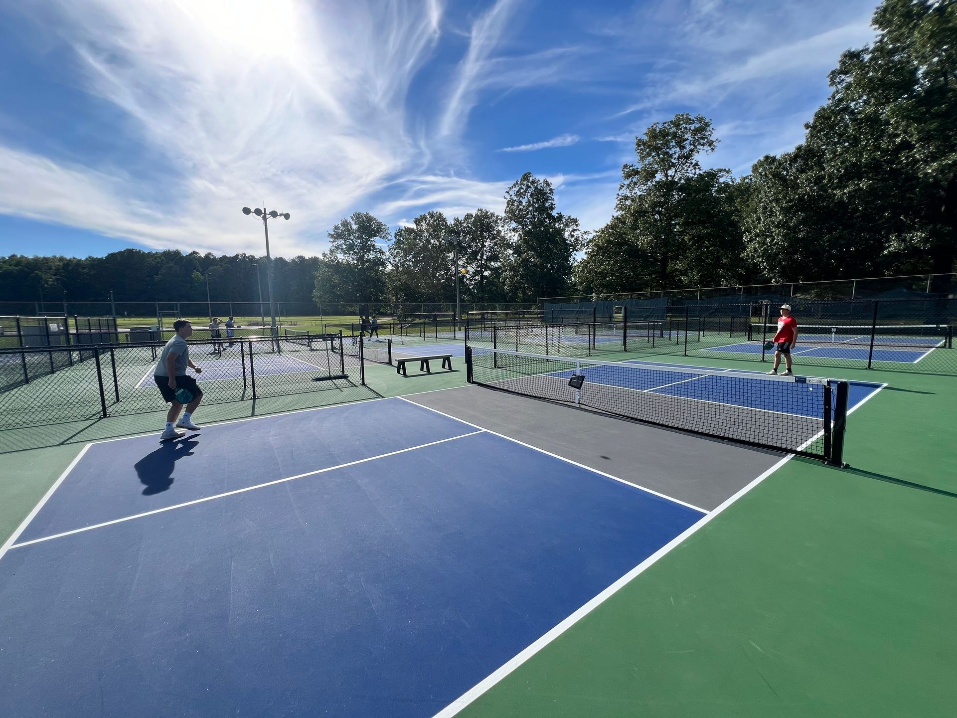 Two people are playing tennis on a tennis court.