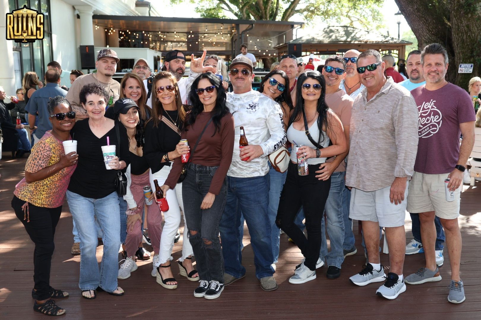 Group of smiling friends posing outdoors in front of a restaurant entrance