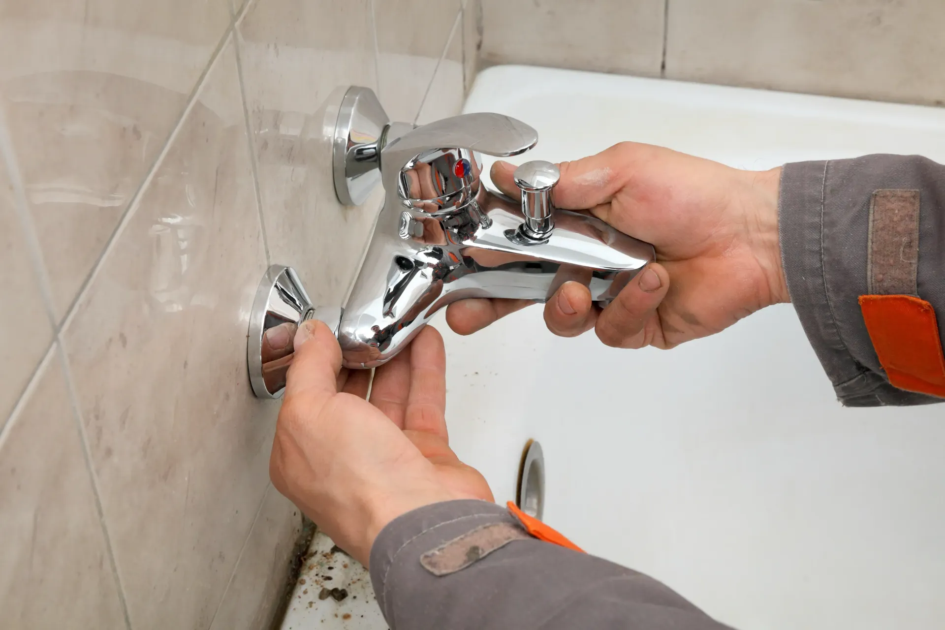 A plumber is fixing a faucet in a bathroom in Vancouver, WA