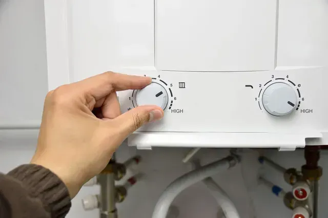 A person is adjusting the temperature on a boiler in Vancouver, WA