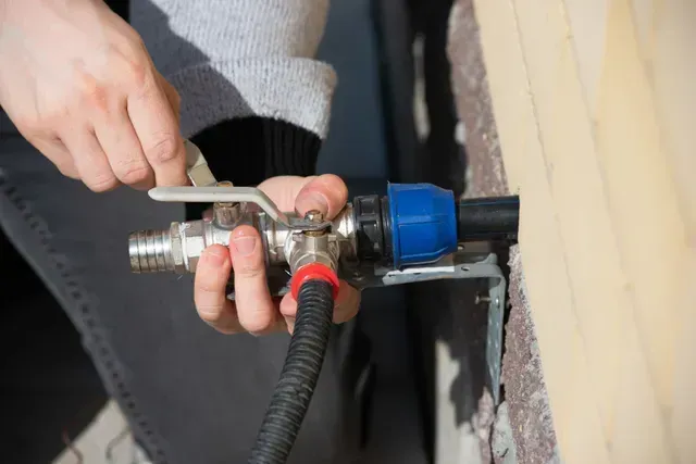 A person is installing a water faucet on a wal in Vancouver, WA