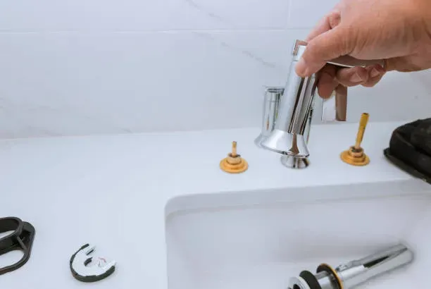 A person is fixing a bathroom sink with a wrench in Vancouver, WA