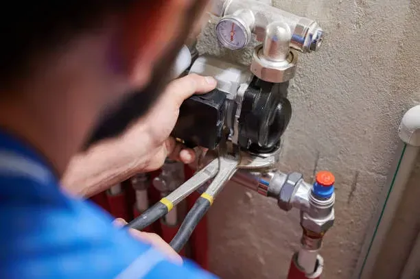 A man is working on a heating system with a pair of pliers in Vancouver, WA