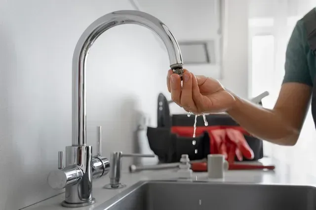 A person is fixing a faucet in a kitchen in Vancouver, WA