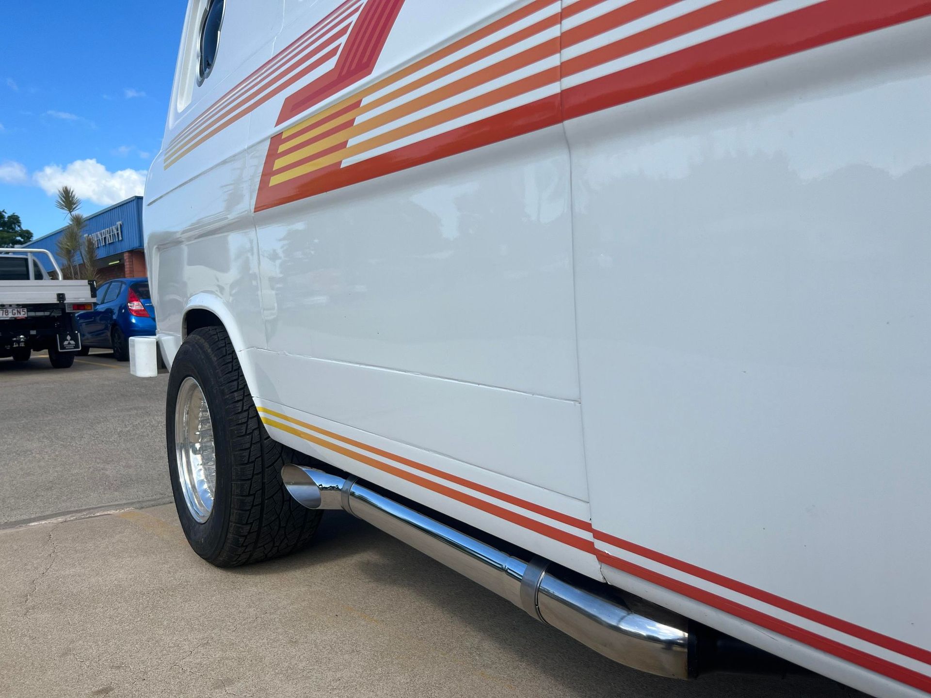 White Van With Red, Orange, and Yellow Stripes — Aitkenvale Exhausts & Towbars Pty Ltd In Aitkenvale, QLD